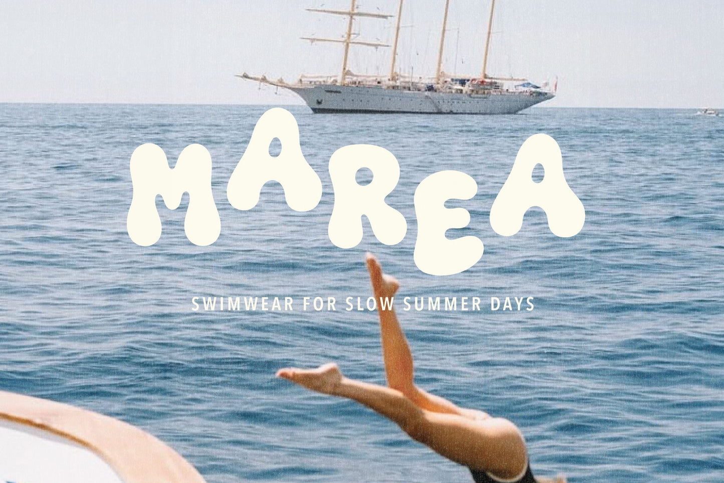 Marea swimwear logo created with The Bubble Club playful display font in white hand-drawn lettering over a Mediterranean sailboat and ocean photograph.